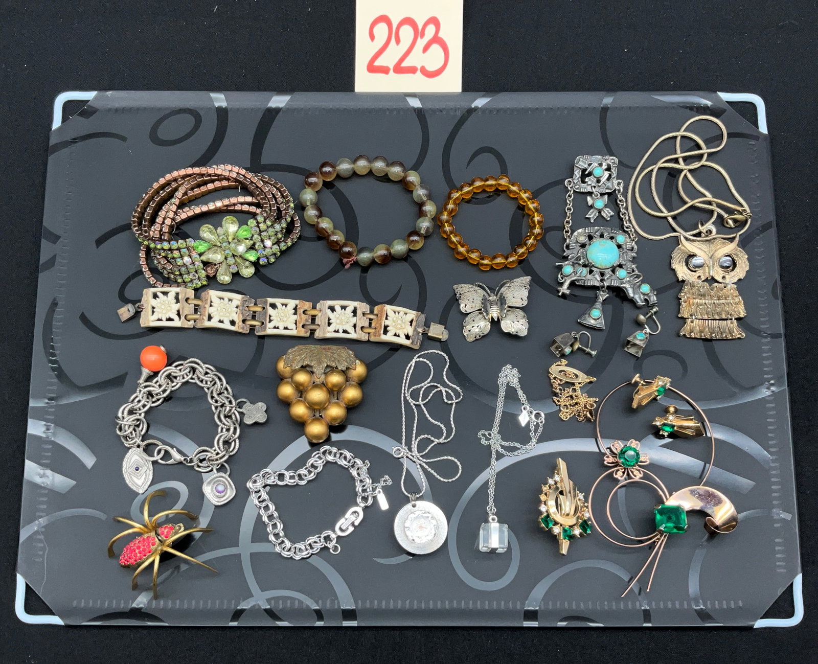 An Assortment of Vintage Costume Jewelry: This collection features a variety of vintage costume jewelry, including a Monet silver-tone charm bracelet and a Carolee cube pendant necklace. Notable items include a Sheffield Swiss-made pendant