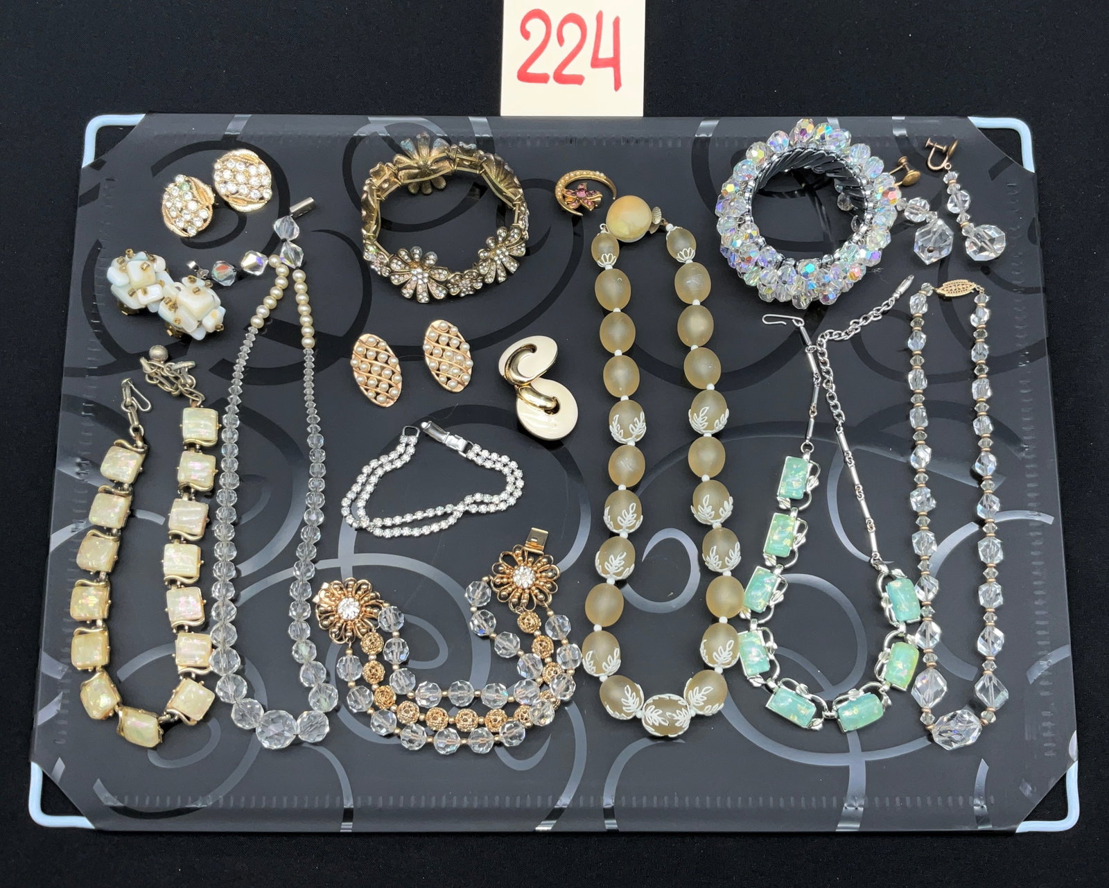 A Collection of 16 Pieces of Vintage Costume Jewelry Including Trifari and Scandia: This collection of sixteen pieces of vintage costume jewelry includes mid-century necklaces, bracelets, earrings, and a pin. Signed items feature gold-tone swirl clip-on earrings marked Trifari, a