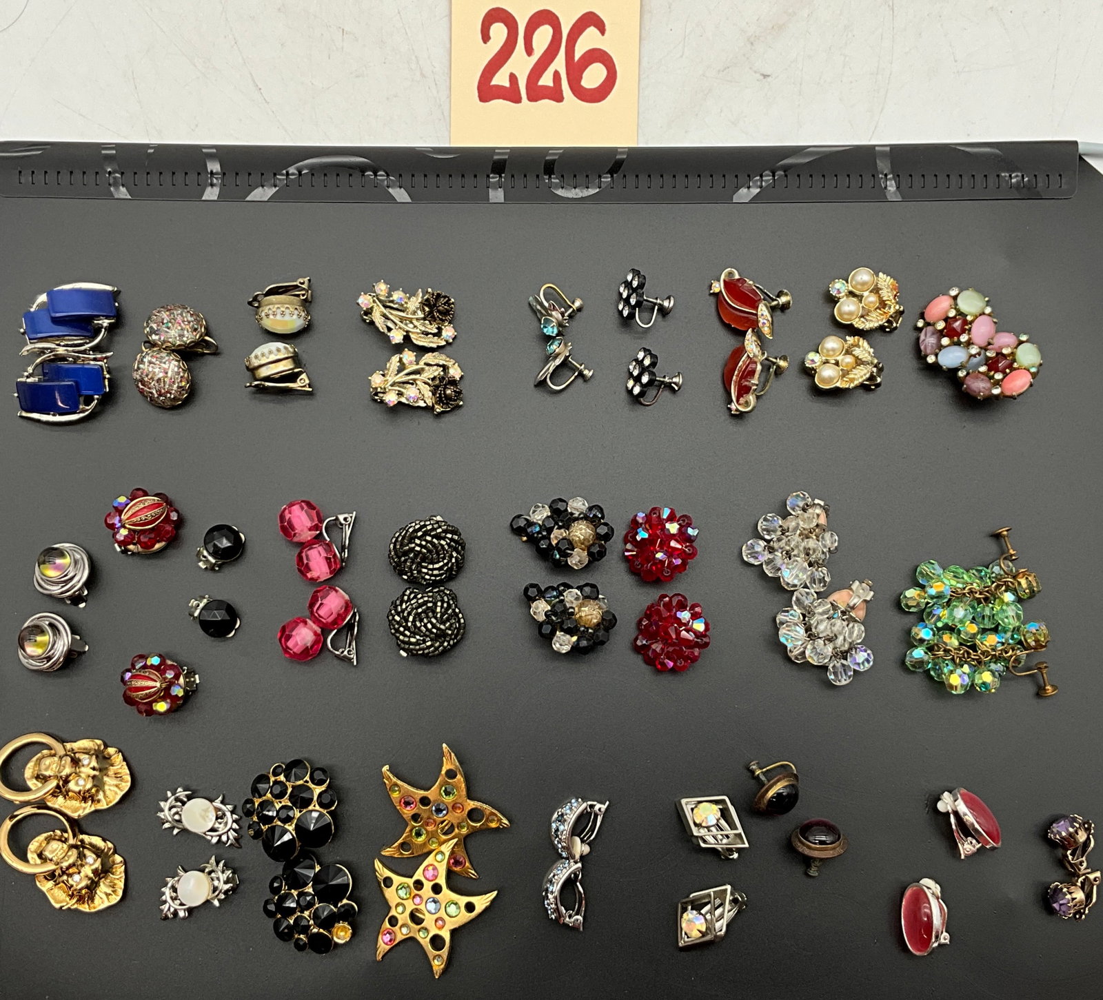A Collection of Vintage Costume Clip-on and Screw-back Earrings: This collection of vintage costume earrings features an assortment of mid-to-late 20th-century styles including beaded clusters, figural motifs, and geometric designs. Materials include gold-tone and
