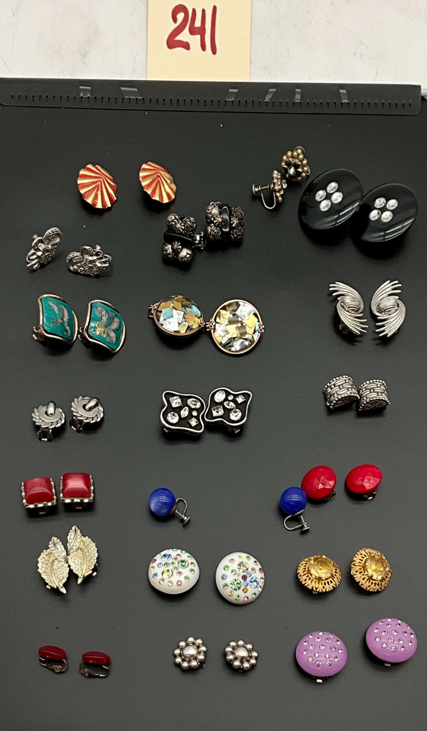 A Collection of Vintage Costume Jewelry Earrings: This collection features vintage clip and screw back earrings in a variety of mid-century styles featuring enamel, mother-of-pearl mosaic, and rhinestone accents. Several pieces bear designer marks