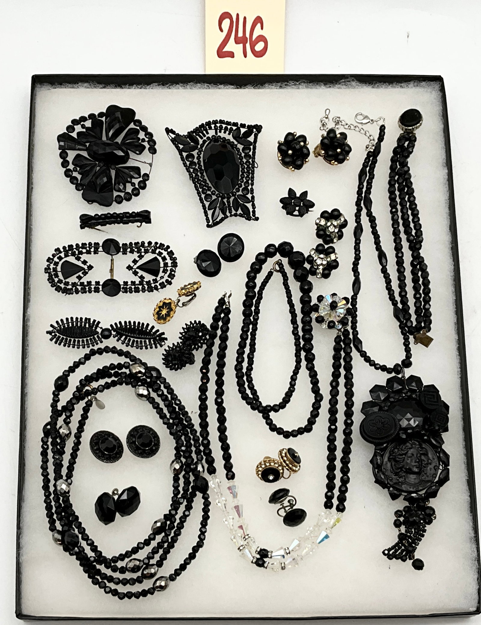 Lot of Vintage Black Jet Glass Mourning Costume Jewelry: This lot of 16 vintage and modern black jet glass mourning costume jewelry pieces features an assortment of necklaces, earrings, brooches, a bracelet, and ornaments in Victorian Revival and Art Deco s
