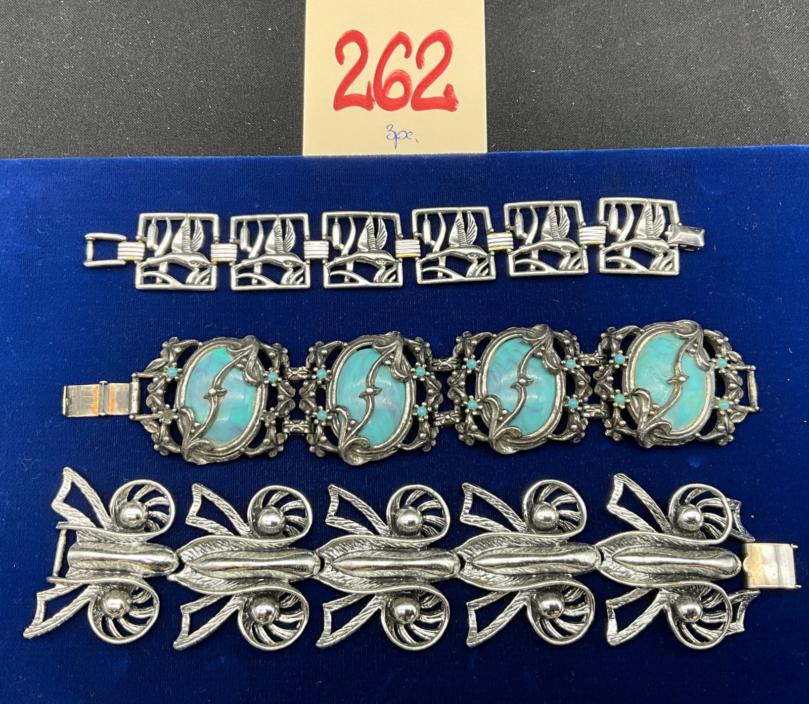 A Trio of Vintage Silver-Tone Costume Jewelry Link Bracelets: This assortment of three vintage costume link bracelets features an ornate piece set with four marbled light blue glass cabochons and small turquoise-colored beads. A second silver-tone bracelet is co