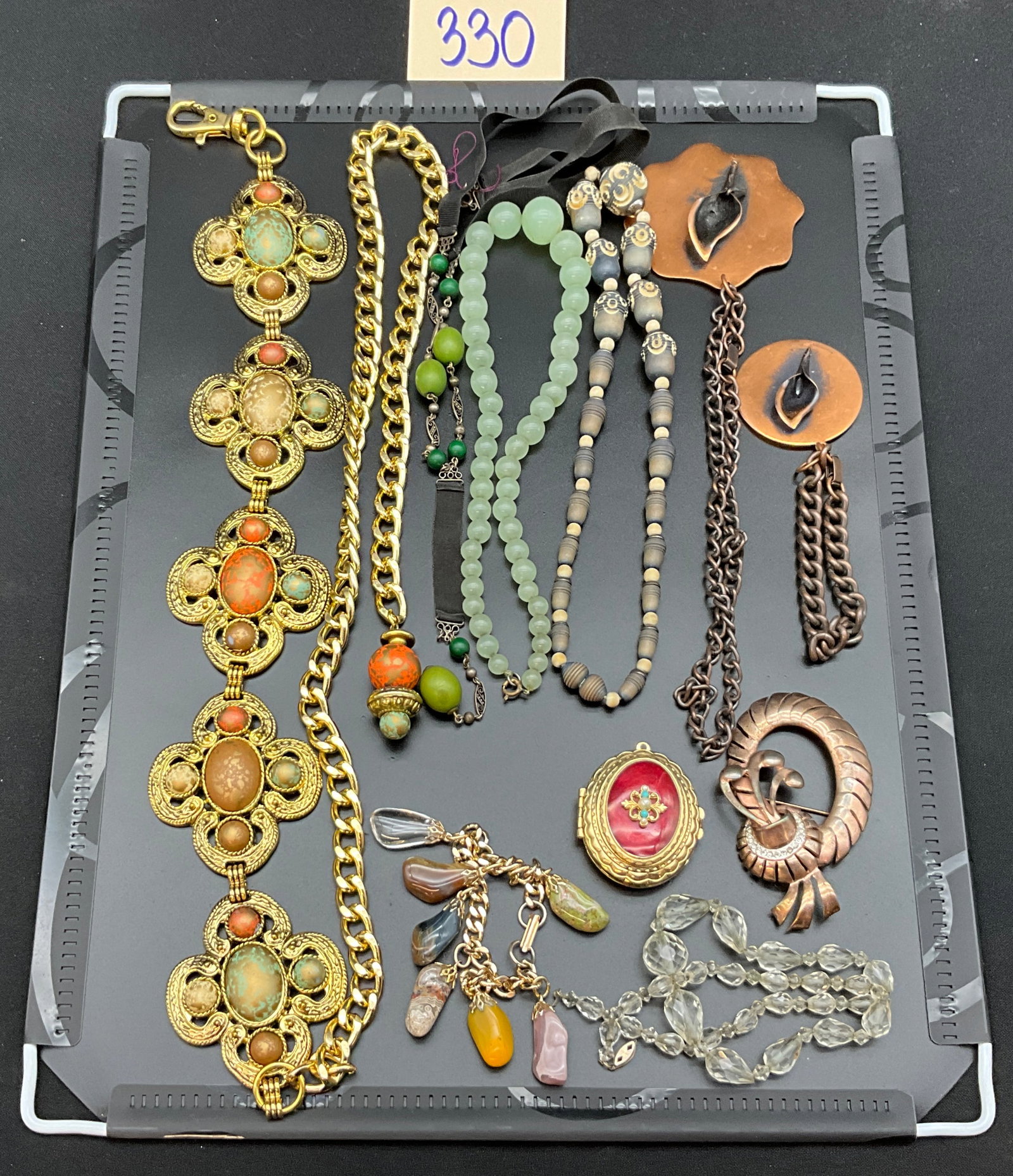 A Collection of Vintage Modernist and Bohemian Costume Jewelry, as-is: This lot consists of multiple pieces of vintage costume jewelry, featuring a large gold-tone quatrefoil medallion belt and a red guilloche enamel locket with faux turquoise accents. The collection