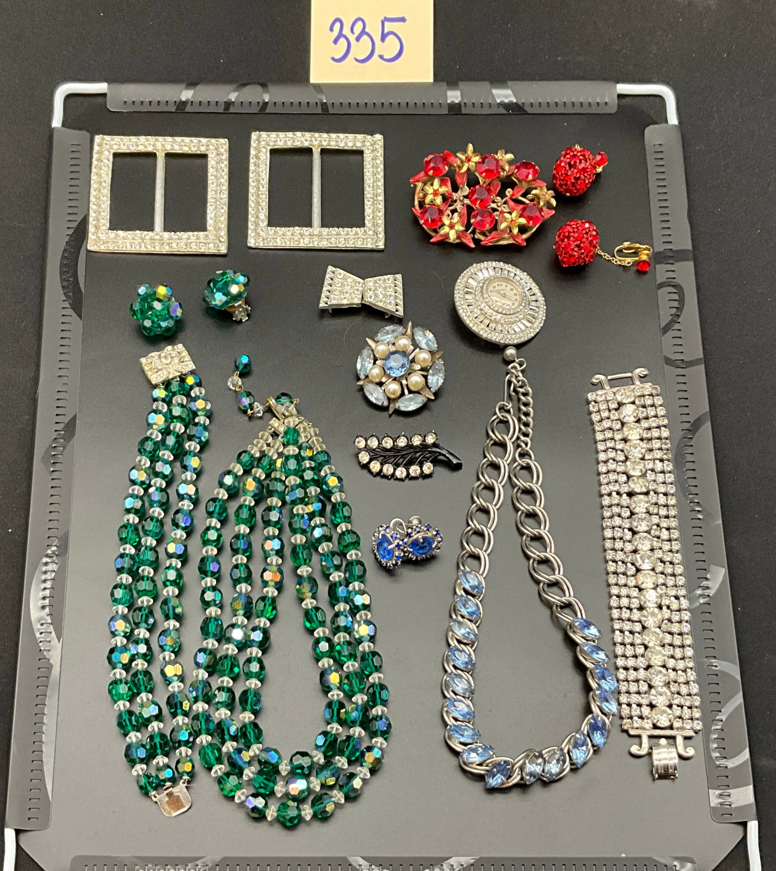 An Assortment of Vintage Rhinestone and Glass Costume Jewelry: This collection features an assortment of mid-20th-century costume jewelry including faceted glass bead sets, rhinestone-accented accessories, and a pendant watch. The lot includes a three-strand gree