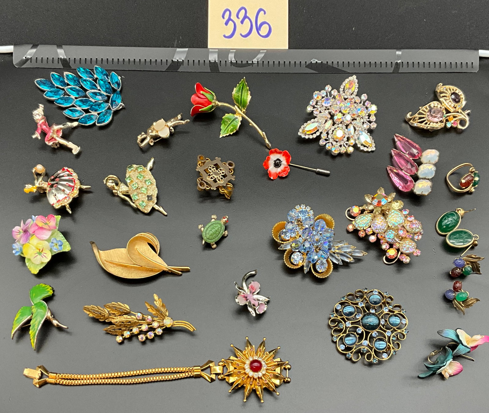 A Collection of Vintage Mid-Century Costume Jewelry: This collection of approximately 25 pieces of vintage mid-century costume jewelry features an assortment of brooches and earrings constructed from gold-tone and silver-tone base metals. Decorative ele