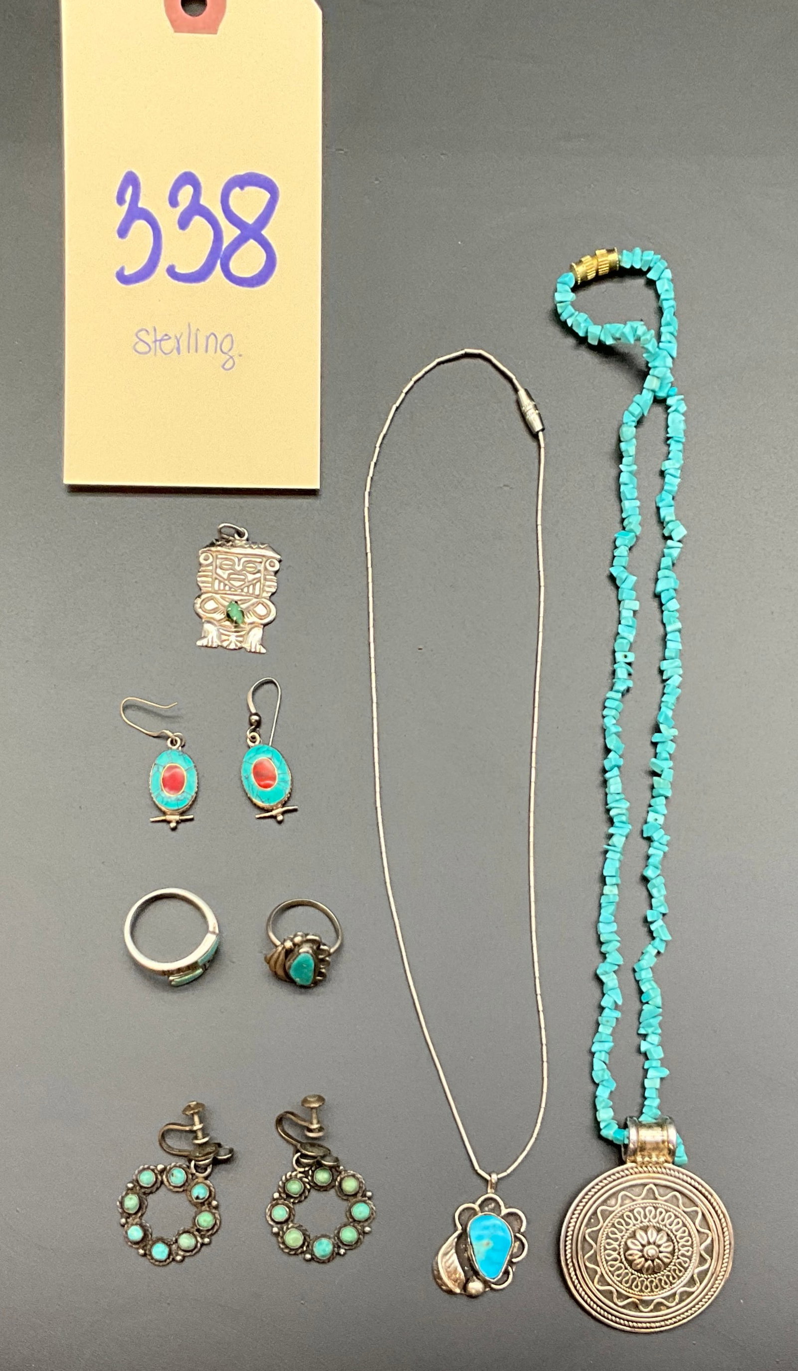 Vintage Southwestern Style Silver and Turquoise Jewelry Collection: This collection features an assortment of Southwestern style sterling silver jewelry set with turquoise and red stone cabochons. The lot includes two necklaces, two rings, a pair of drop earrings, a