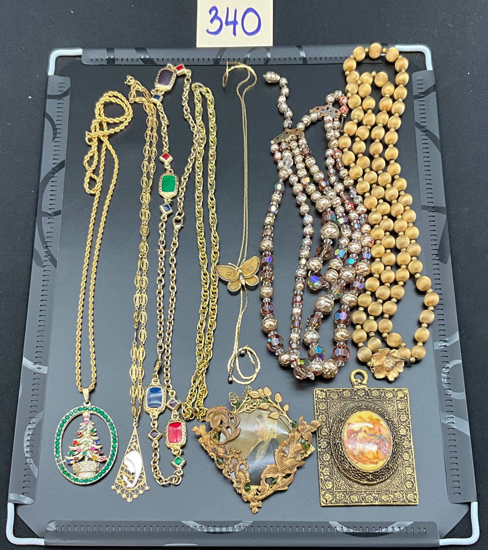 A Collection of Vintage Gold-Tone Costume Jewelry, as-is: This lot consists of an assortment of vintage gold-tone costume jewelry featuring statement pendants, multi-strand beaded necklaces, and ornate brooches. The collection is decorated with multi-colored