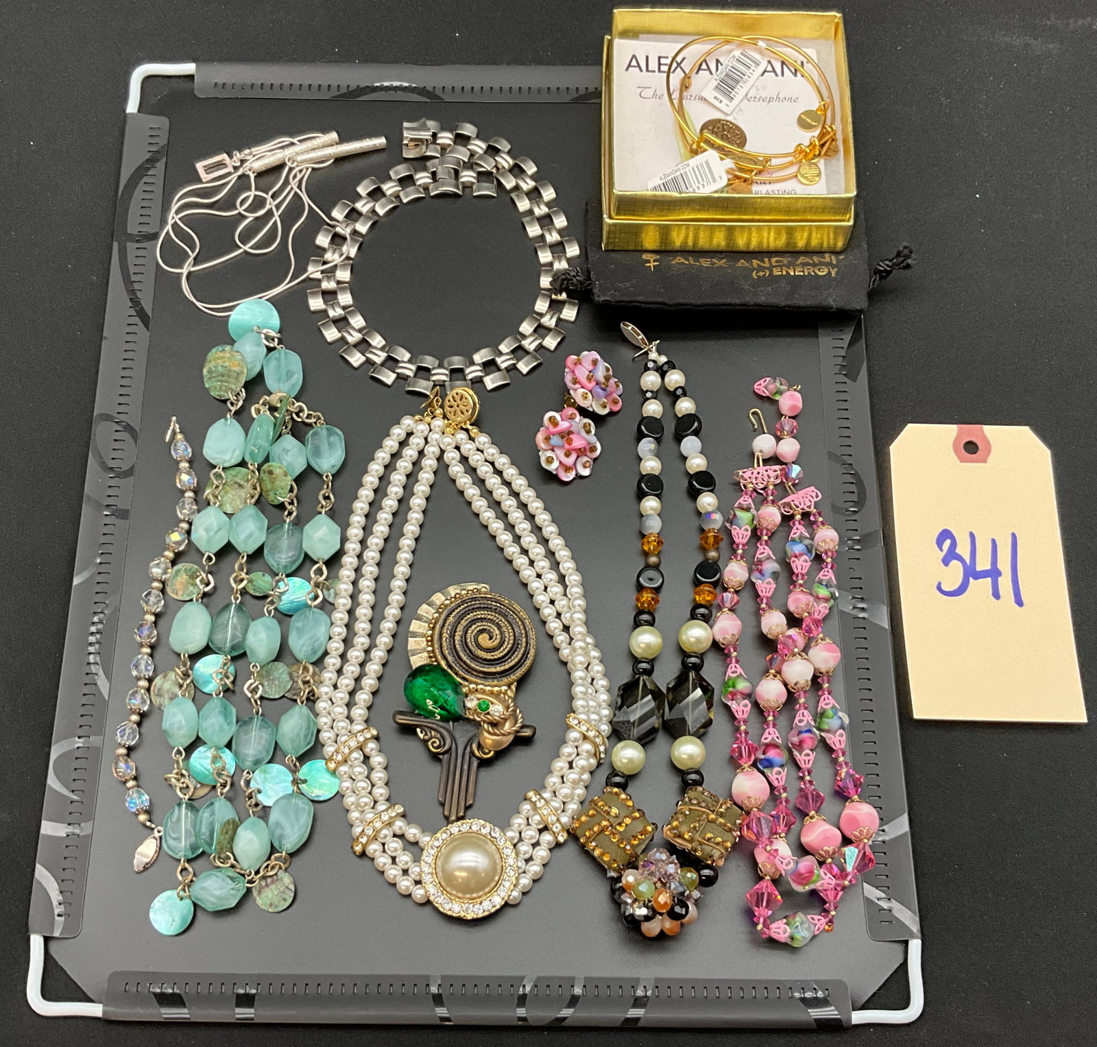 A Collection of Vintage Costume Jewelry: This collection of vintage costume jewelry features an assortment of beaded necklaces, a large mixed-media brooch, and a pair of floral cluster earrings. Included items consist of a triple-strand faux