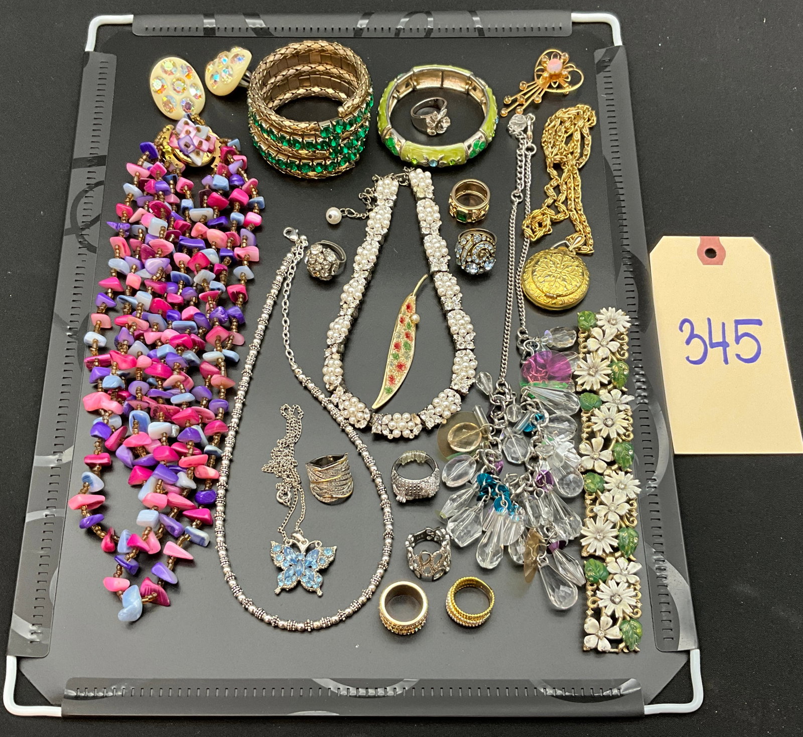 An Assortment of Vintage Costume Jewelry and Sterling Silver Rings: This assortment of vintage costume jewelry features a diverse range of necklaces, bracelets, rings, and brooches. The collection includes a white enamel floral bracelet, a multi-strand beaded necklace