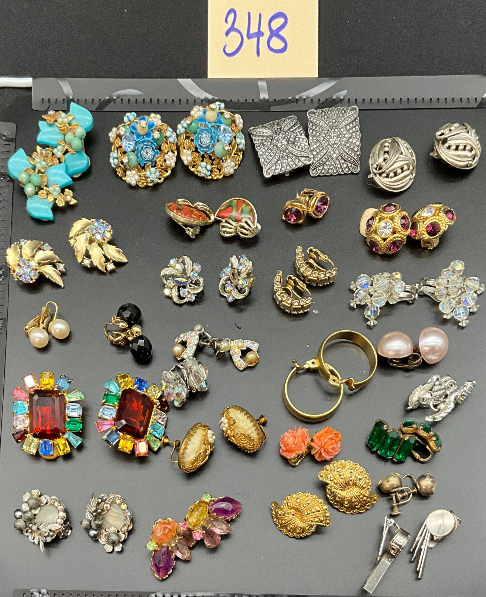 A Collection of Vintage Costume Jewelry with Coro Signed Pieces: This collection features an assortment of vintage costume earrings and tie bars in gold-tone and silver-tone base metals. The set includes clip-on and screw-back styles adorned with rhinestones, faux 