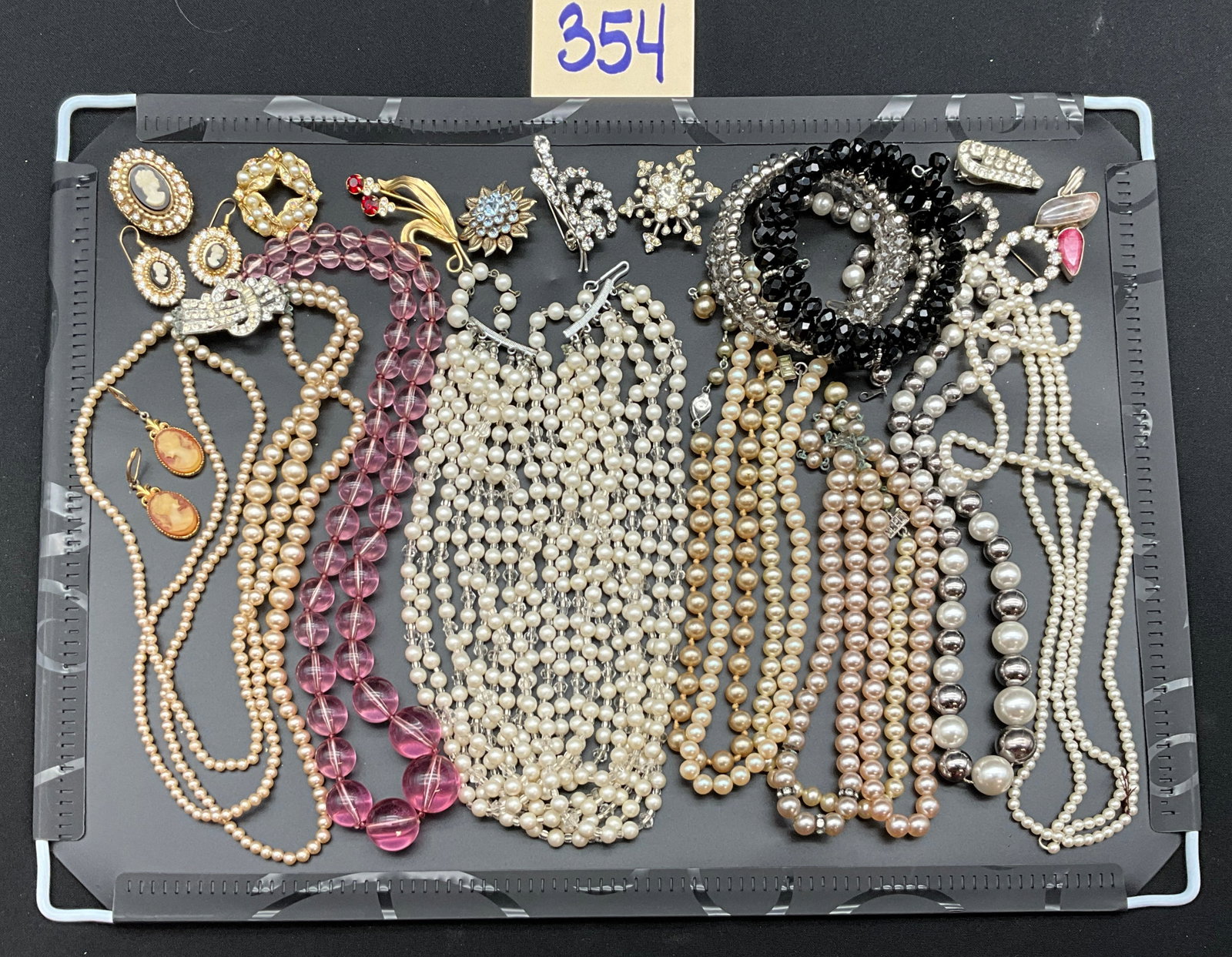 A Collection of 25 Vintage Costume Jewelry Pieces: This lot consists of 25 pieces of mid-century costume jewelry including multi-strand necklaces, brooches, earrings, and beaded bracelets. The items are constructed from gold-tone and silver-tone metal
