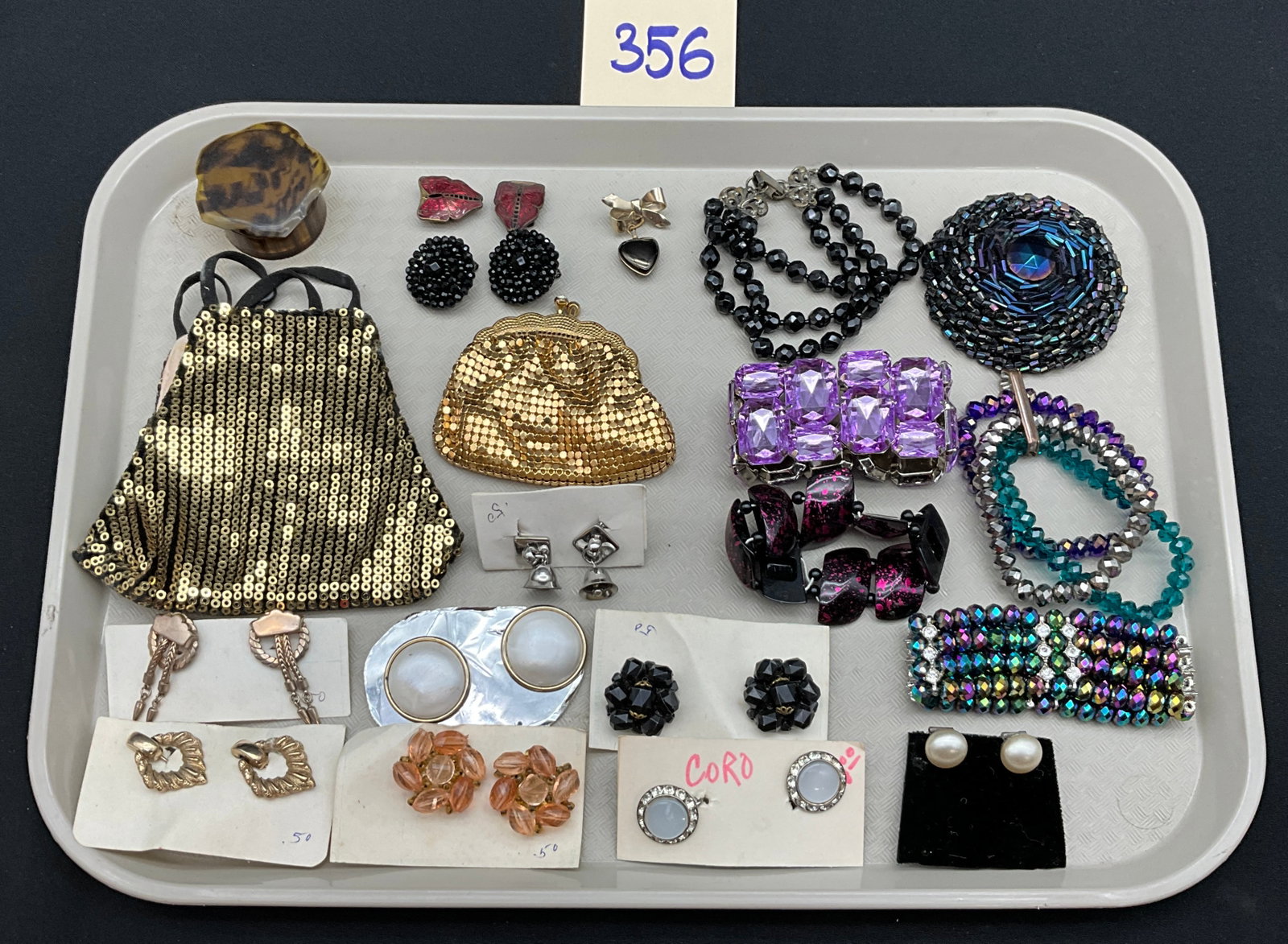 A Collection of Vintage Costume Jewelry and Accessories: This collection features a diverse assortment of mid-century costume jewelry and vintage accessories including two evening bags, various bracelets, and a statement brooch. The lot includes a gold-tone