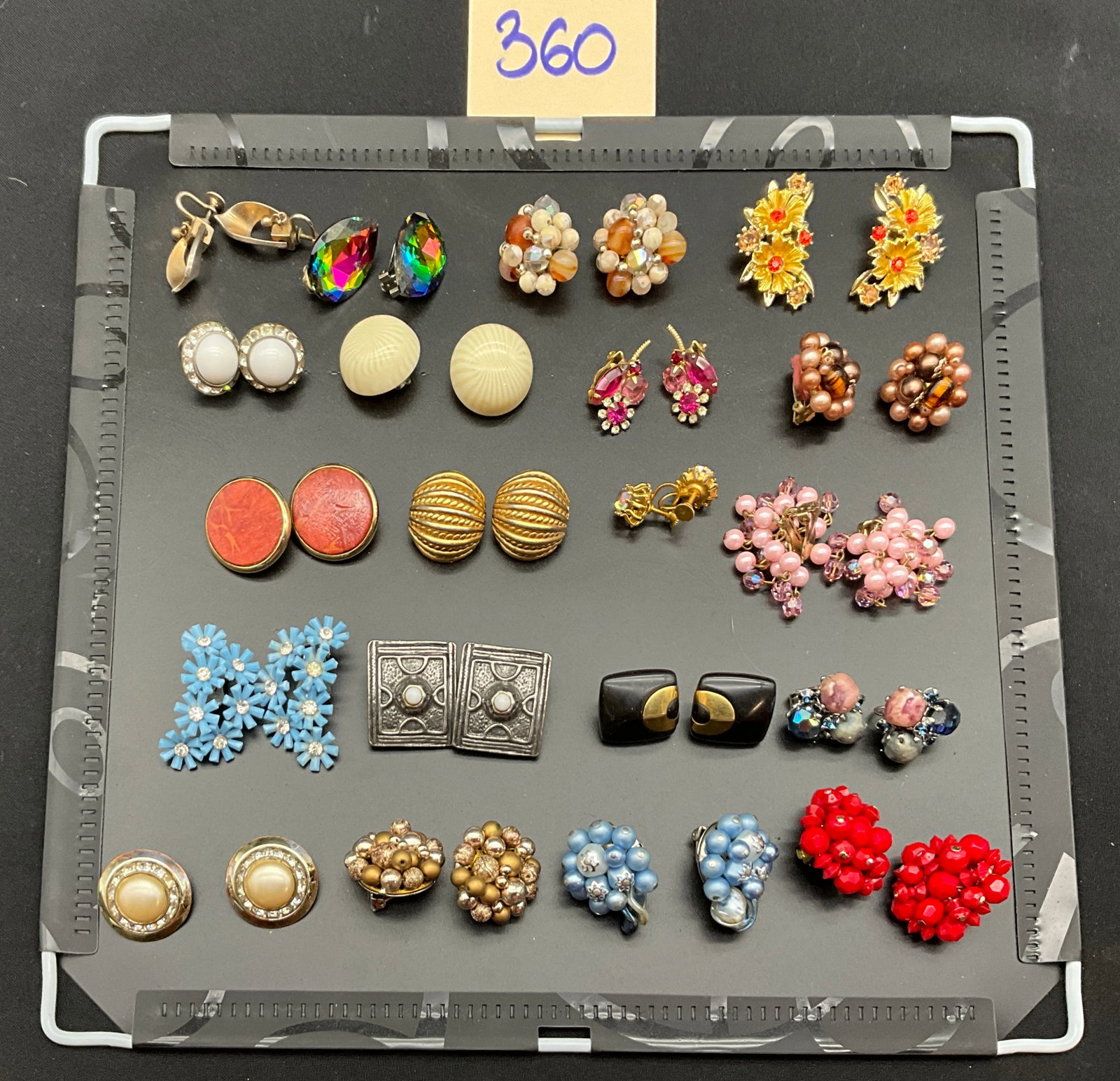 A Collection of Vintage Costume Jewelry Earrings: This collection of vintage costume earrings features an assortment of clip-on, screw-back, and post-back styles. The pieces are constructed from gold-tone and silver-tone metals and are decorated with