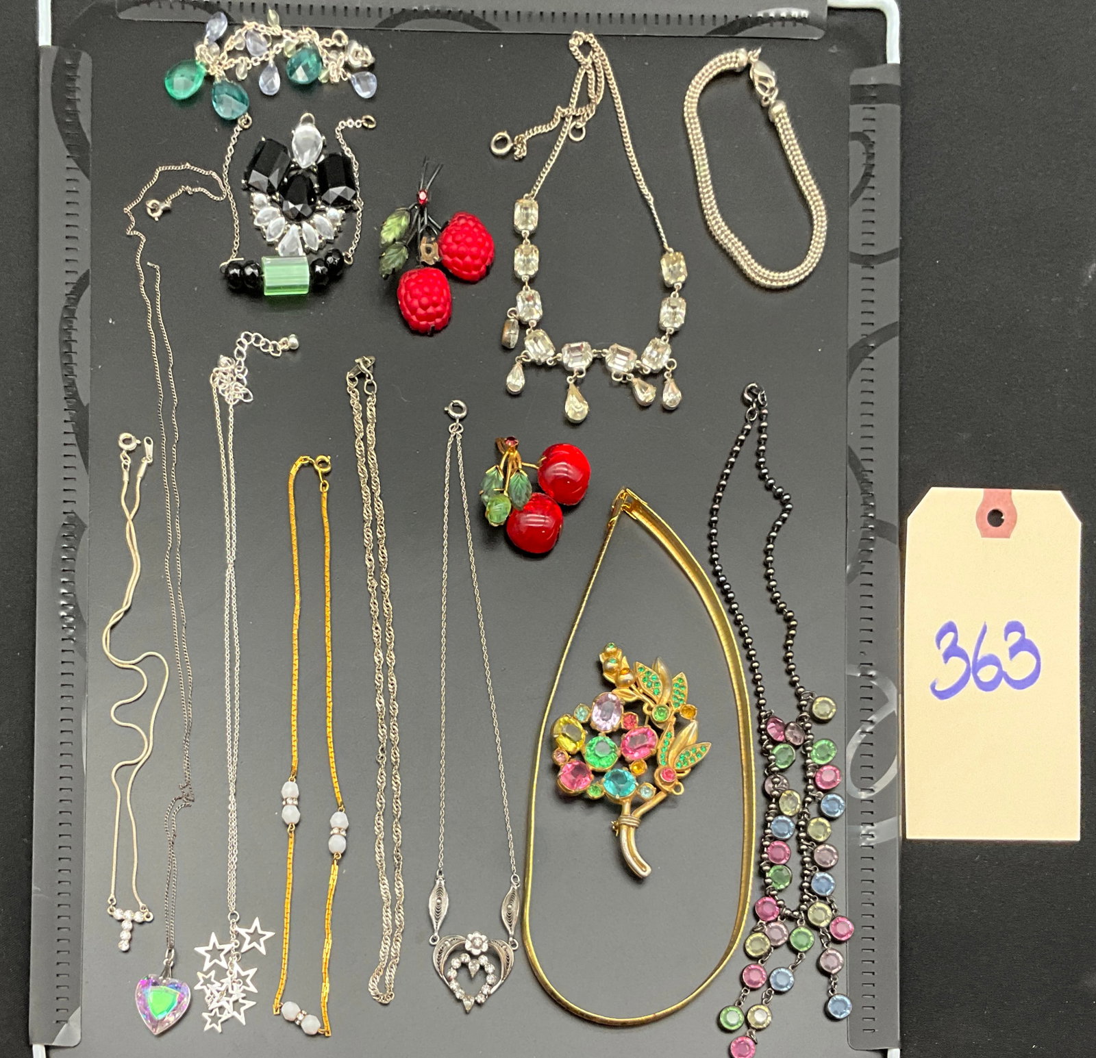A Collection of Vintage Costume and Silver Jewelry Items: This collection of jewelry items features a variety of necklaces, brooches, and a bracelet executed in mid-century and contemporary styles. Notable pieces include a multicolored floral bouquet brooch 