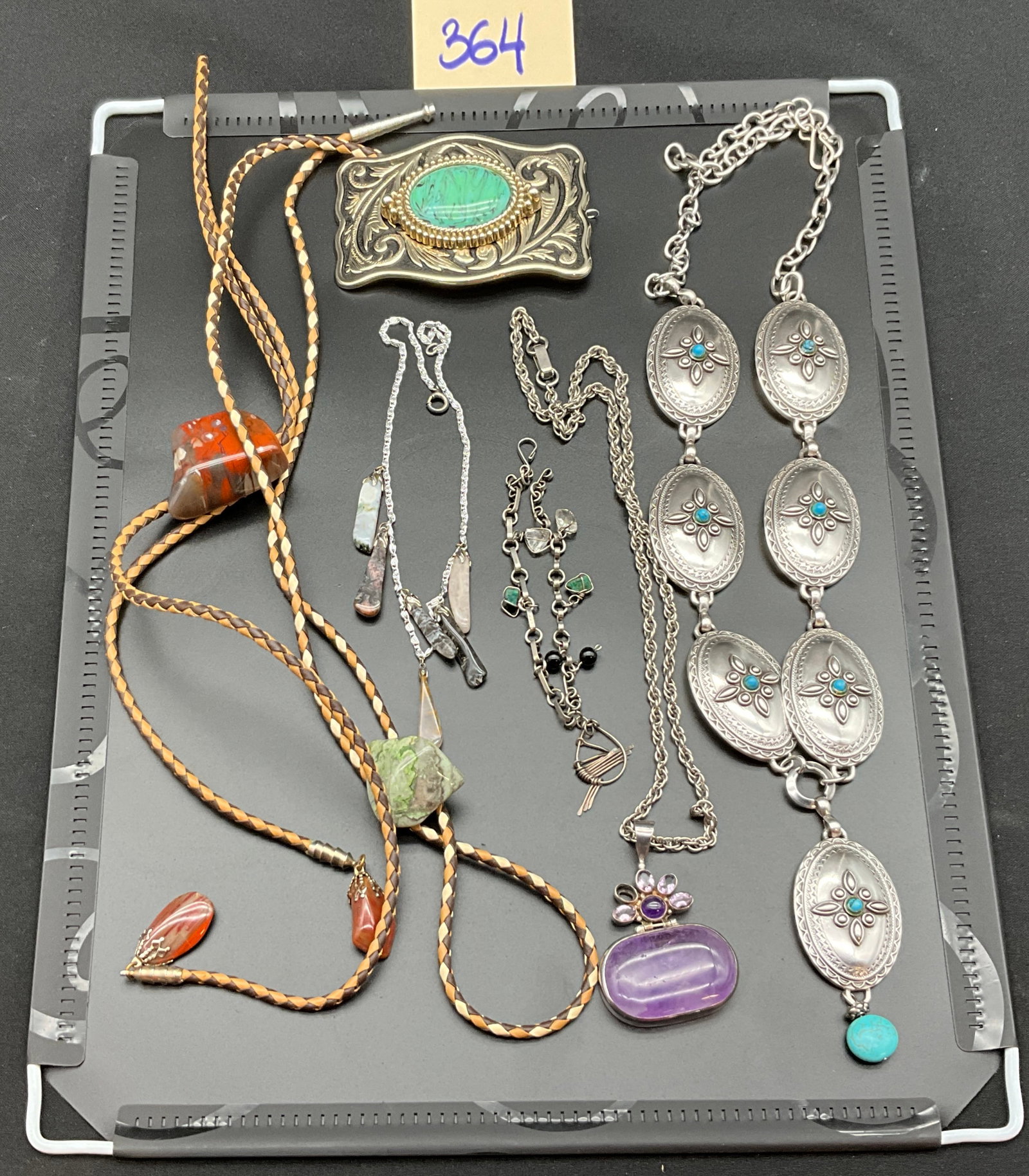 A Collection of Vintage Southwestern Style Silver and Gemstone Jewelry: This collection of vintage Southwestern style jewelry includes a silver-tone concho belt set with turquoise-colored beads and a braided leather bolo tie featuring a polished jasper slide. The lot