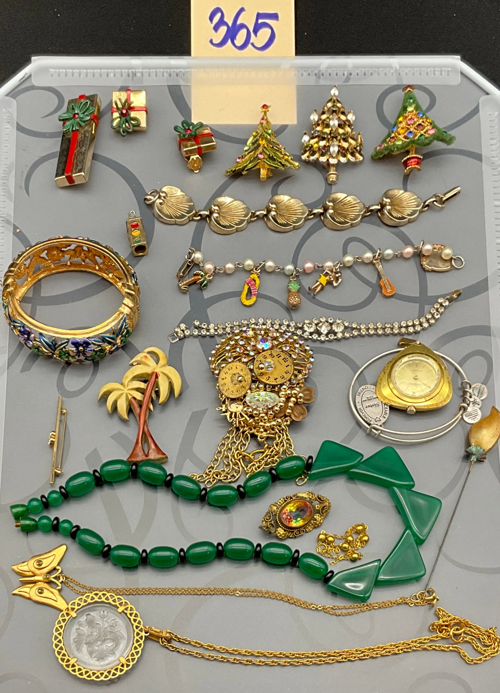 A Collection of Vintage Holiday and Artisan Costume Jewelry: This collection features an assortment of vintage costume jewelry including brooches, necklaces, bracelets, and a bangle watch constructed from base metals, enamel, molded plastic, and glass. A large 
