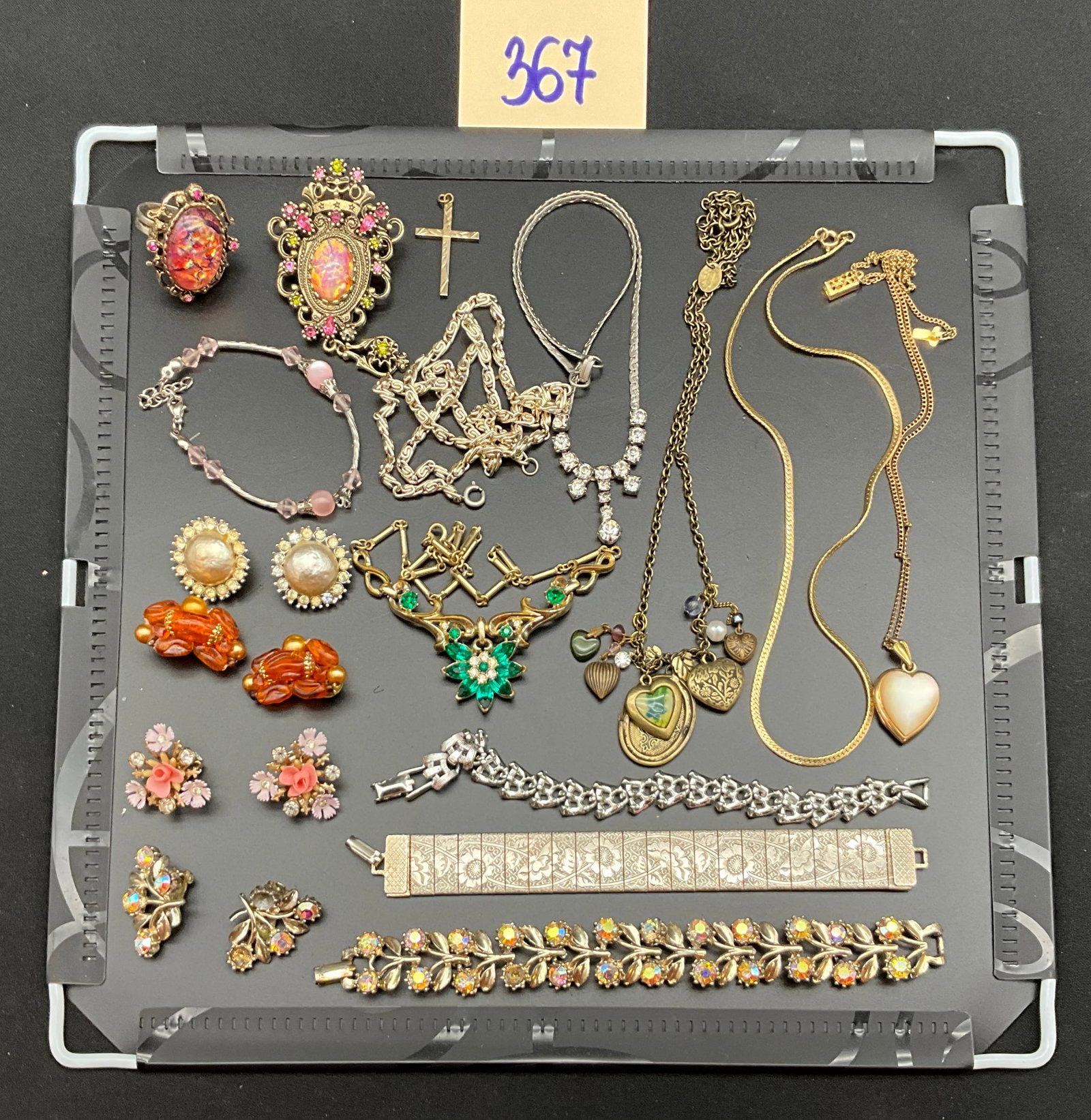 A Collection of Vintage Mixed Metal Costume Jewelry: This collection features an assortment of vintage costume jewelry including several necklaces, bracelets, clip-on earrings, and a ring. The pieces are fabricated from gold, silver, and brass-tone