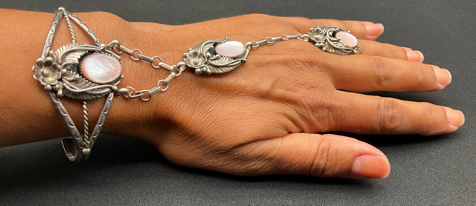 Vintage Navajo Style Silver and Pink Mother of Pearl Slave Bracelet: This vintage Navajo style silver slave bracelet features a split-shank cuff connected by a linked chain to a matching split-shank ring. Three oval pink mother-of-pearl cabochons are set in sawtooth