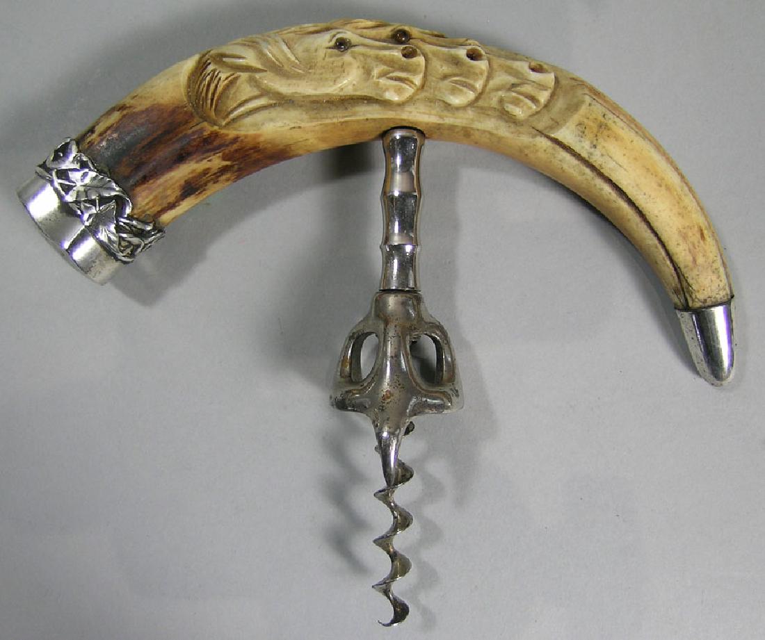 Boar's Tusk Corkscrew, late 19th C., sterling silver: Boar's Tusk Corkscrew, late 19th C., sterling silver mounts and having carved horse heads with glass eyes, also having a Walker Bell feature, 7 1/4" wide, 5 3/4" long.