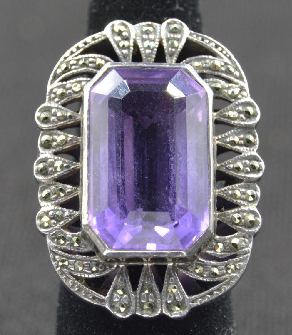 Sterling Silver and Amethyst Ladies Ring: Amethyst being approx. 14 carats; surrounded by Marcasites; size 6 1/2