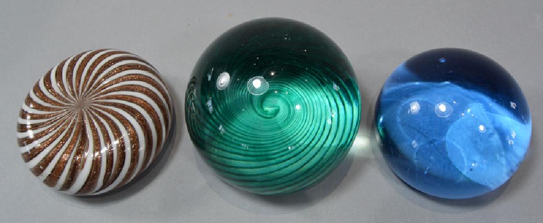 Three-Contemporary Glass Paperweights: two having a swirl pattern with one being signed indiscernibly, the largest being 2 3/4" dia., 2 1/4" high.