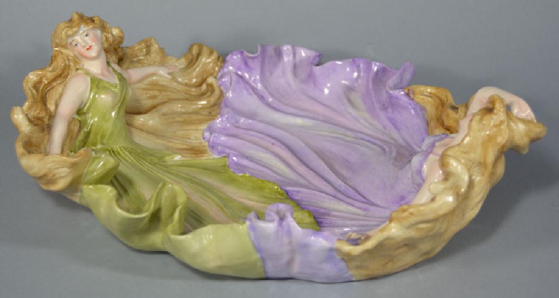 Antique German Figural Fruit Bowl: having two female figures with flowing dresses, having blue double crossed swords underglaze mark, possibly Schierholz, 13" long, 10 3/4" wide, 4 1/8" high.