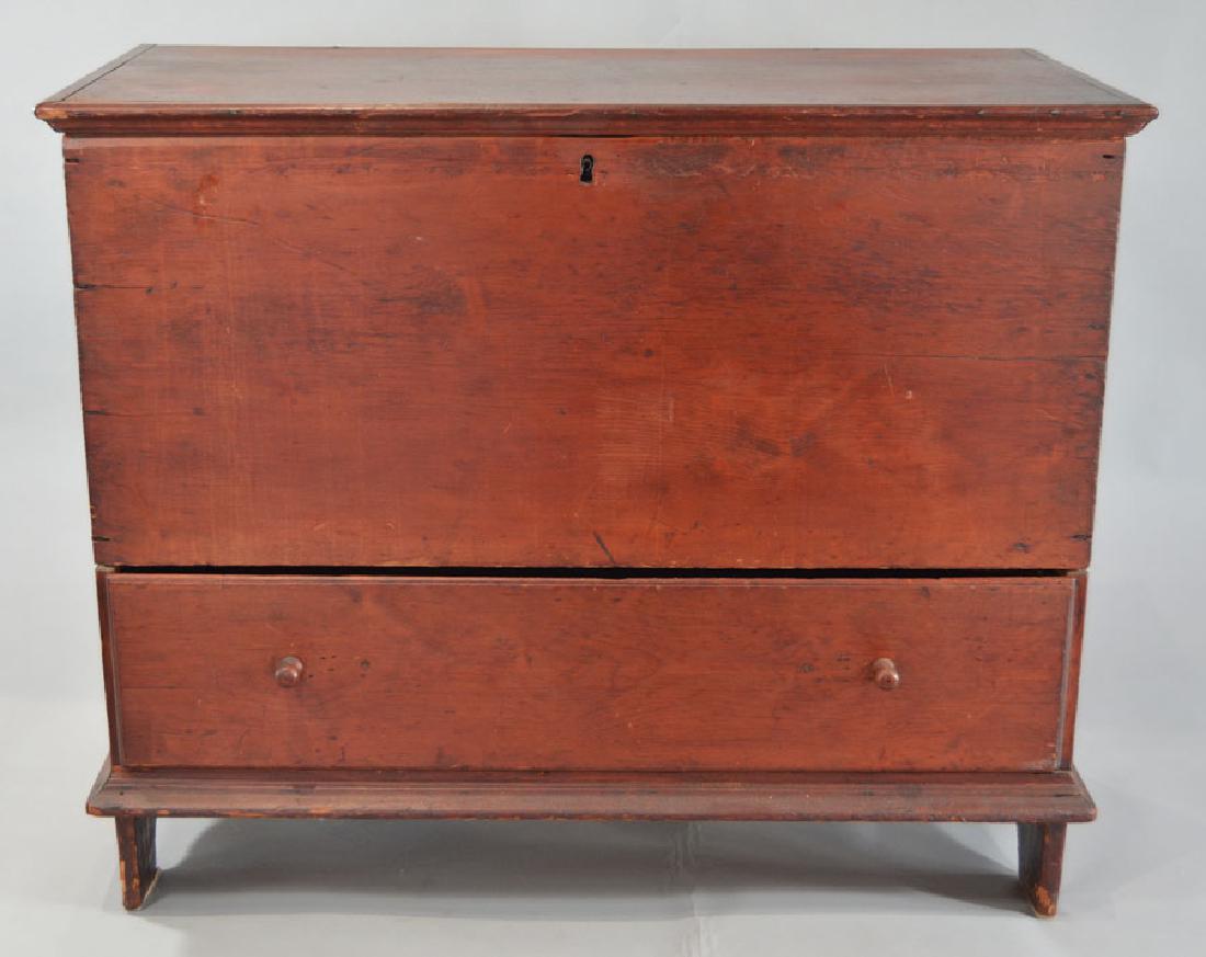 Early 19th C. Six-Board Lift Top One Drawer Blanket: pine construction throughout, snipe hinges, red wash, shaped boot jack cutouts, interior having a till box with cover, 41" wide, 20" deep, 33 1/2" high.