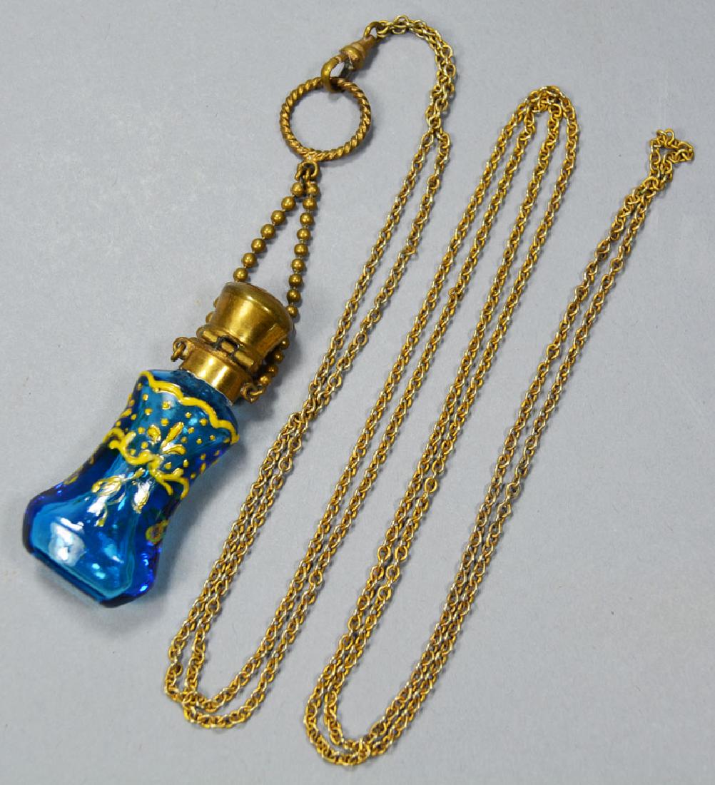 Antique Enameled Perfume Pendant: 2 3/8" blue glass waisted form bottle with gold color enameling having gilt highlights, on a 48" chain.