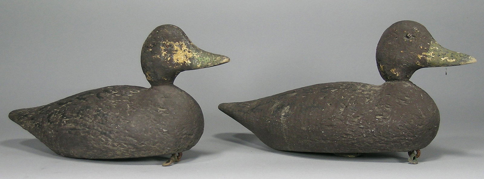 A Pair of Antique Carved Wooden Duck Decoys: both paint decorated, having glass eyes and lead weights attached to the underside, both being 16 1/4" long.