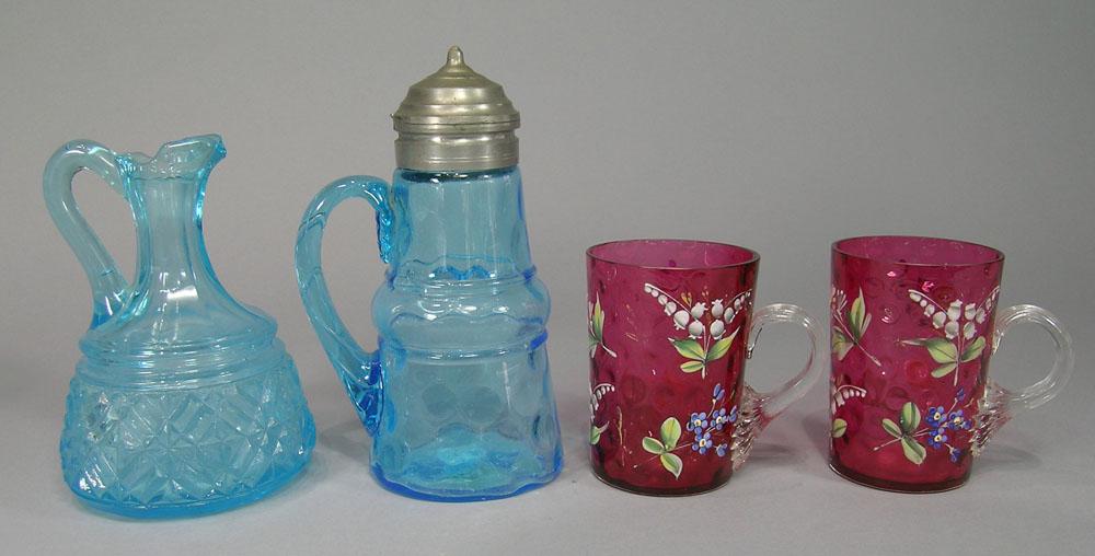 Four 19th C. Glass Tables Articles: Comprising a blue coin spot syrup pitcher with applied handle having interior intertwined veins and terminating in a leaf pattern at top, pewter spout and cover, 6 3/4" H., a pair of cranberry coin sp