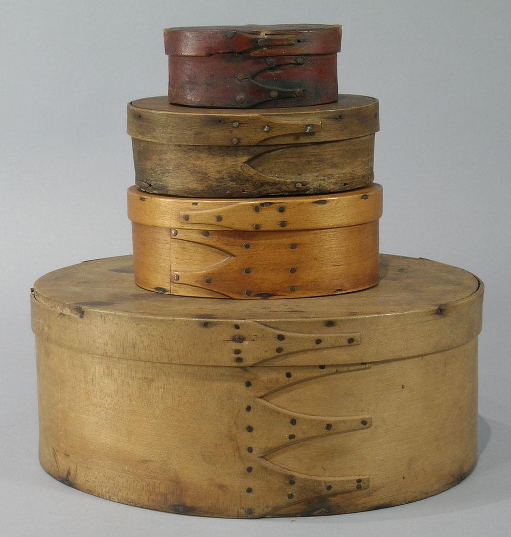 Four Shaker Oval Boxes: three with natural finish the largest being 12" long, 9" wide, 5" high, the smallest having a red/brown heavy wash, 4 3/8" long, 2 7/8" wide, 1 7/8" high.
