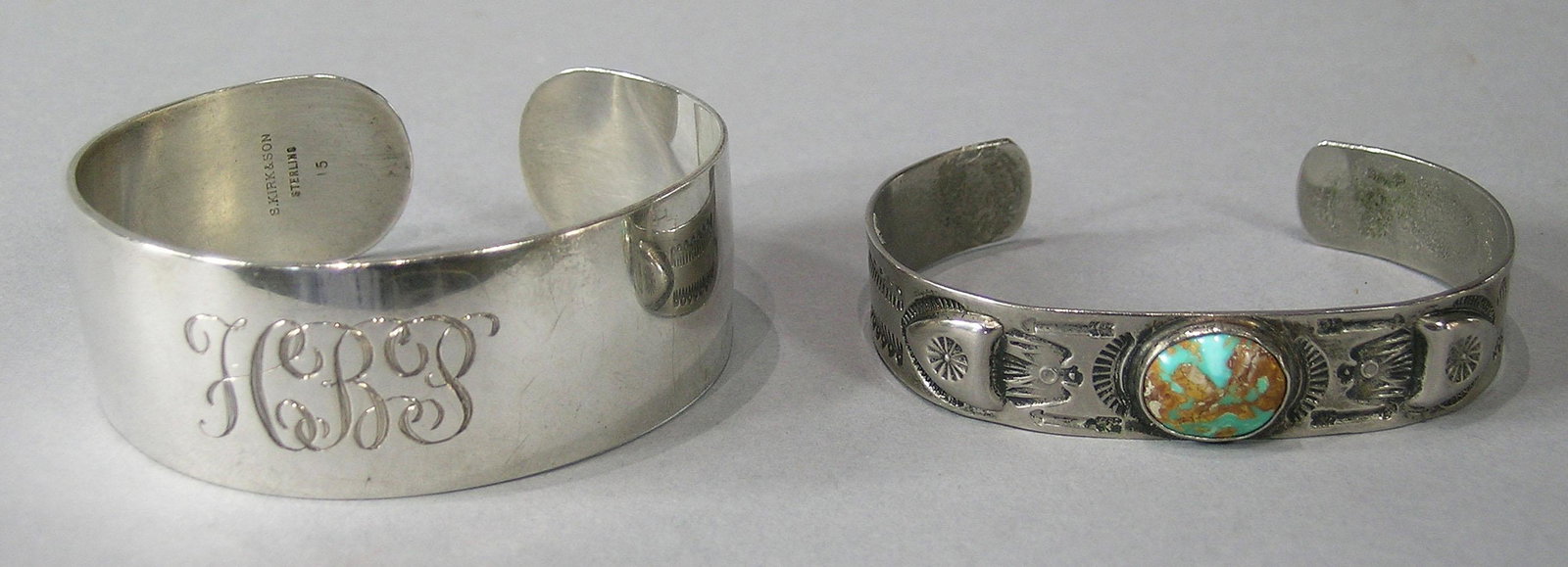 Two Silver Cuff Bracelets: one marked S. Kirk & Son, sterling, 15, 7/8" wide, monogrammed, and a Southwest Native American with a center oval turquoise flanked by eagle decoration, 1/2" wide.