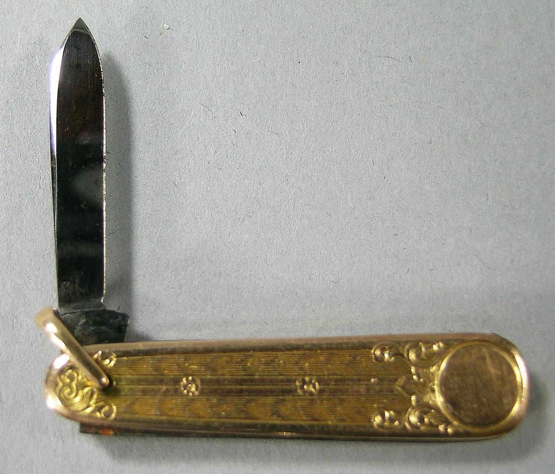 10K Yellow Gold Pocket Knife: single blade, unmarked but tests as 10k, having line, floral and scroll decoration on body 1 1/2" L., blade 1" L.