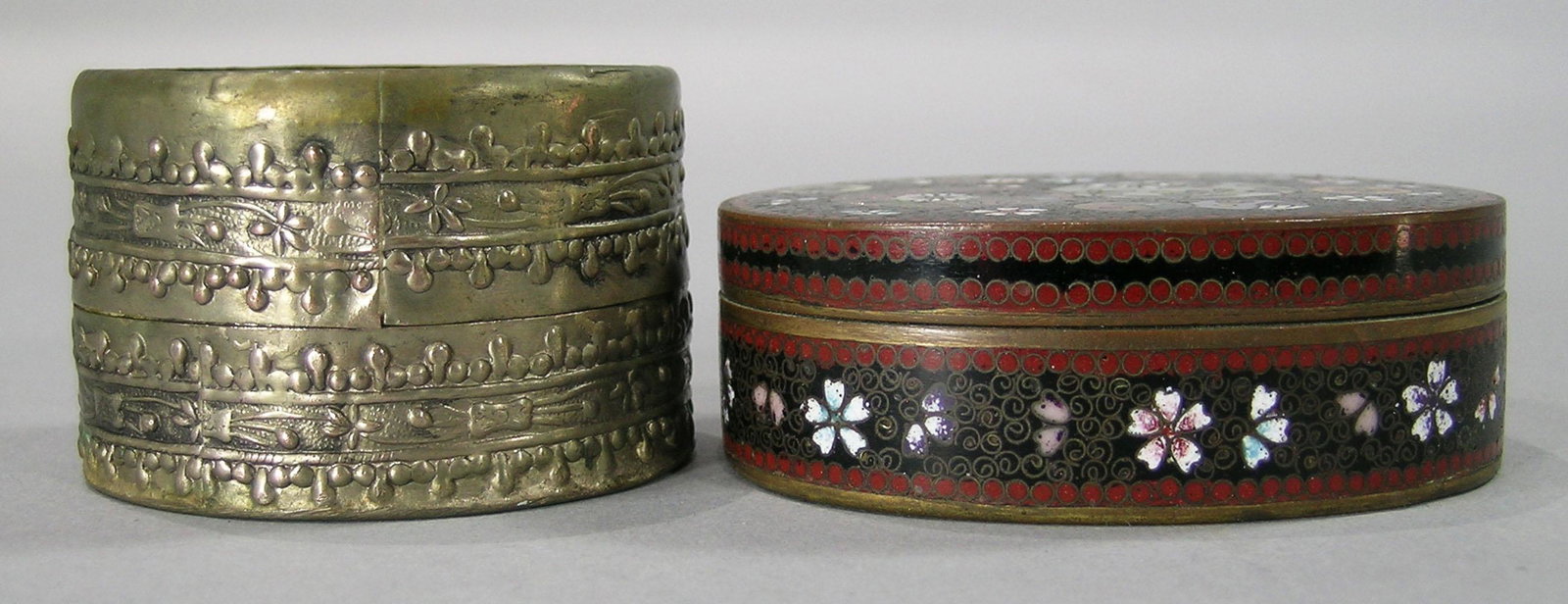 Two Chinese/Japanese Snuff Boxes: one being oval with cloisonnÃ© exterior and blue enamel interior, the other appears to be silver or silver-plated with a glass floral decorated top.