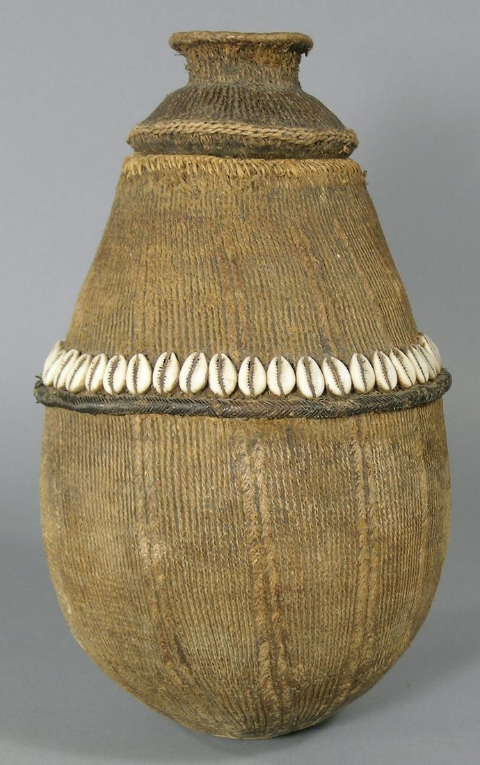 Vintage African Milk Gourd with Cover: Bulbous form, having a decorative woven exterior with a ring of cowrie shells, 6 3/4" dia., 12 1/8" H. Provenance: From a Private Collector in Illinois who acquired the item directly while in Africa i
