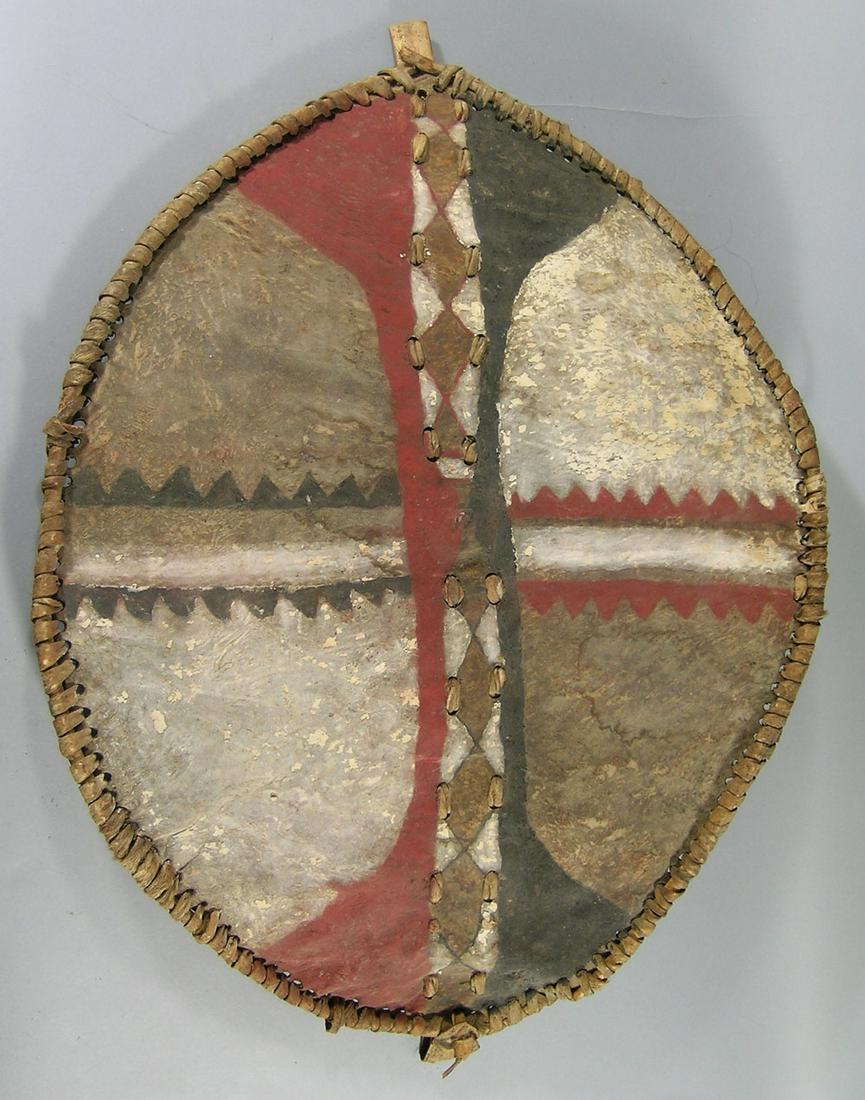 Rare Masai Warrior Shield, Kenya: Early/Mid 20th C., oval shaped having a multi color hand decorated skin on a wooden frame, skin handle on inside, 34" H, 23" W. Provenance: From a Private Collector in Illinois who acquired the item d