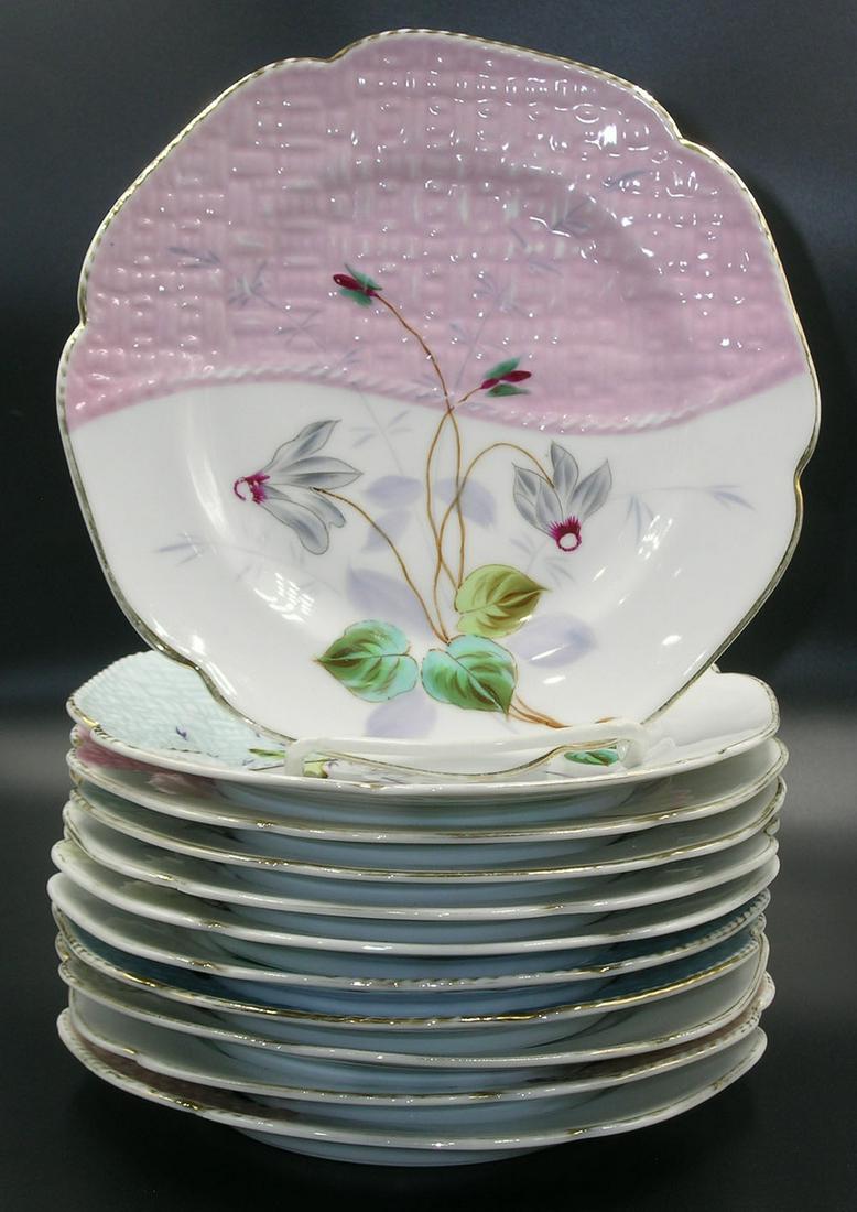 ELEVEN PORCELAIN LUNCHEON PLATES: all being shaped circular form, half of the front of the plate having basket weave in relief with pastel colors, each having various hand painted floral decoration and gilt borders, two also having bu