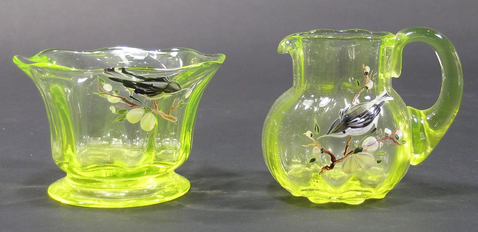 PAIRPOINT VASELINE GLASS SUGAR BOWL AND CREAMER: ribbed optic, both having a hand painted Chickadee on a floral branch, sugar bowl is 4" dia., 2 5/8" high, the creamer is 2 7/8" dia., 3 1/8" high