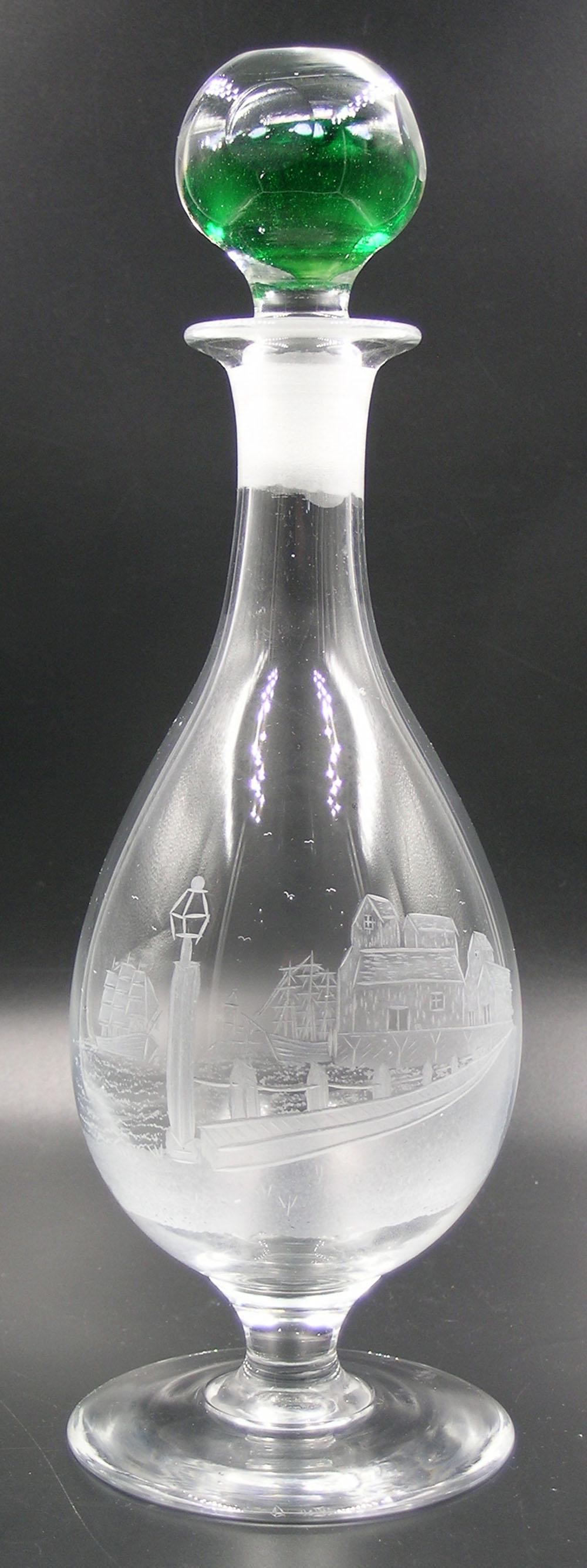 PAIRPOINT GLASS WINE DECANTER: engrave decorated with a Harbor scene, having ships, buildings, street and lamp on lamp post, the stopper having internal dark green glass with millefiori decoration, 11" high to top of stopper, attac