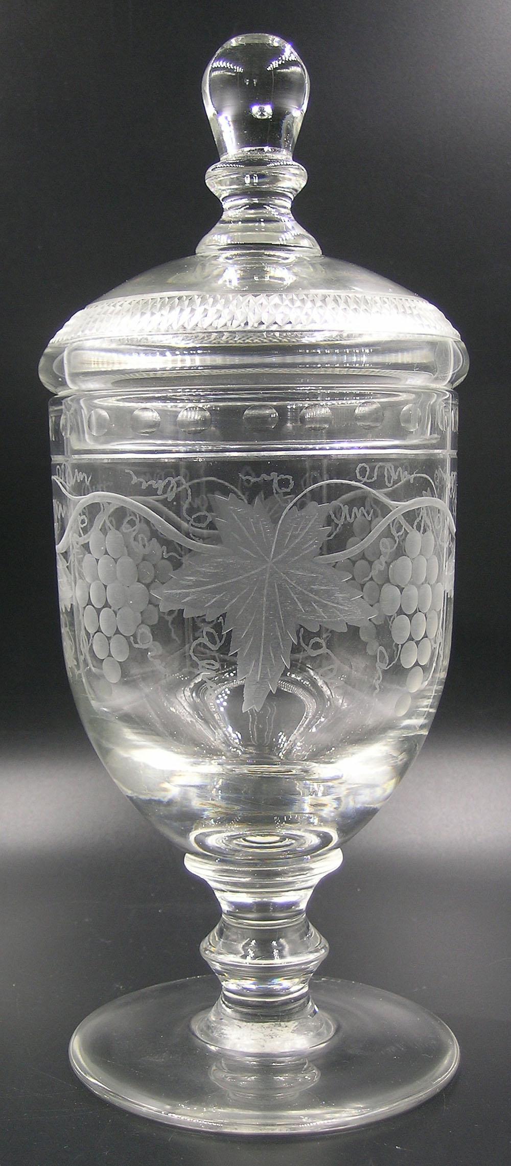 GUNDERSEN PAIRPOINT ETCHED GLASS FOOTED COVERED URN: having etched Grapevine decoration, 11" high, Gundersen Masterpiece label on the underside of the base