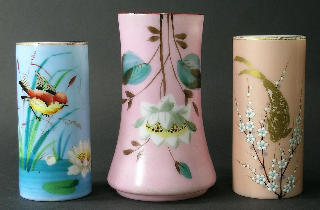 THREE SMITH BROTHERS GLASS VASES: all cylindrical form, one with a blue ground and having a small bird on a cattail in a pond, 6" high, one with a tan ground and having a gilt koi and enamel flowers, 6" high, and one flaring form with