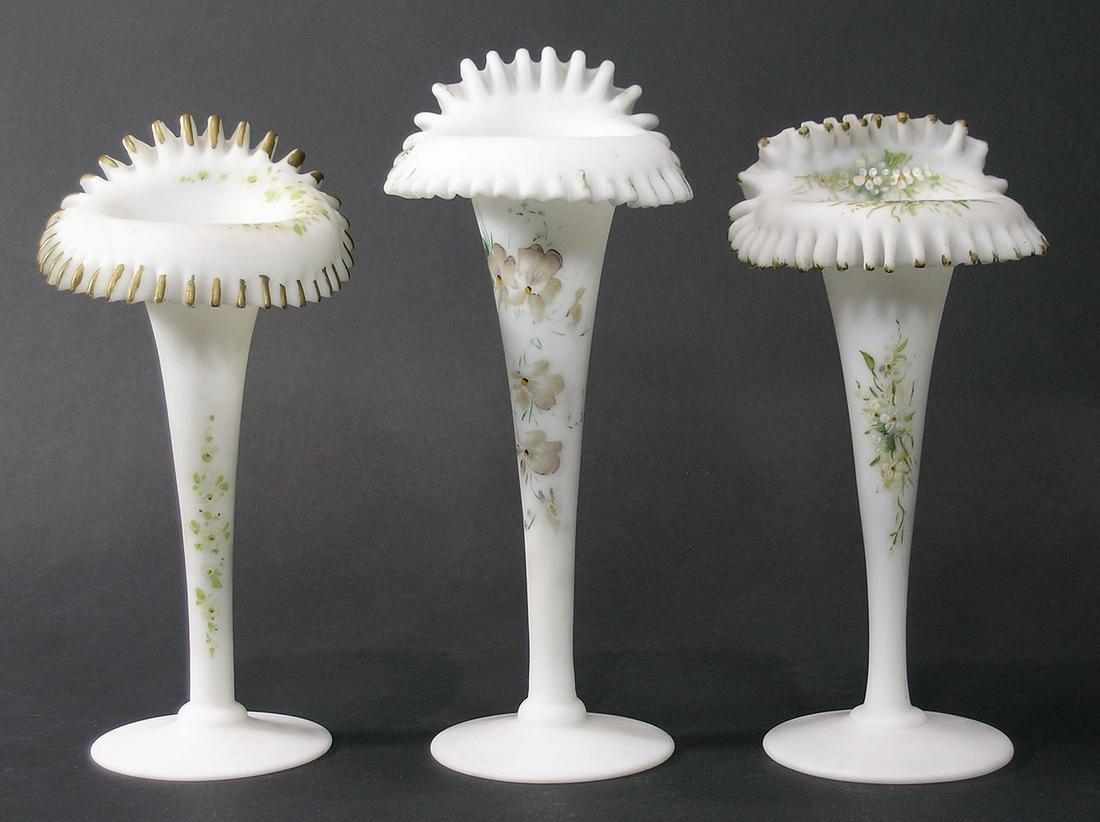 THREE MT. WASHINGTON GLASS JACK-IN-THE-PULPIT VASES: white satin glass, hand painted floral decoration, ruffled rims with gilt highlights, polished pontils, the tallest being 9" high