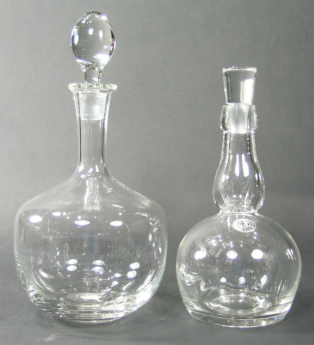 TWO GUNDERSEN MASTERPIECE GLASS DECANTERS: colorless glass, each being of bulbous form, one having a shaped neck, one being 10" high, the other 12 1/4" high, both having original silver labels