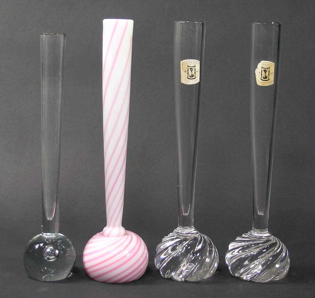 FOUR PAIRPOINT GLASS BUD VASES: all having ball form bases, comprising one colorless glass having an entrapped air bubble in base, 10" high, two colorless glass having twist form bases and paper labels, 10 1/2" high each, and one in