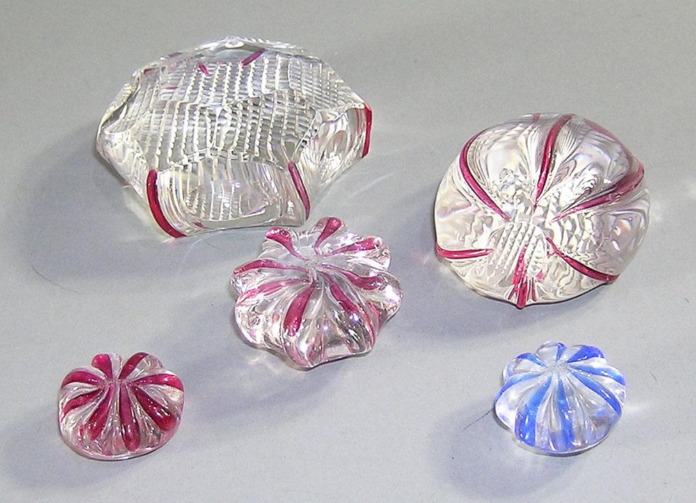 FIVE PAIRPOINT END OF DAY GLASS PAPERWEIGHTS: all colorless glass with red or blue accents, the largest being 2 3/4" hexagon.