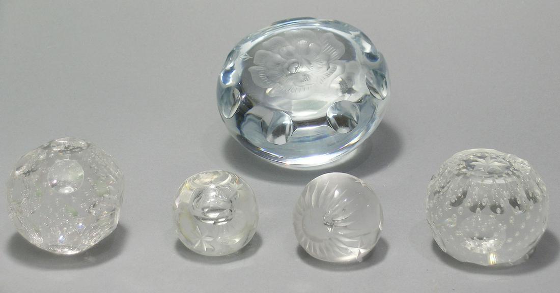 FIVE COLORLESS GLASS PAPERWEIGHTS: all probably Pairpoint, all having various entrapped air bubbles, three having etched decoration with the largest having an etched flower decoration on the top and being 3 3/4" dia., 2" high