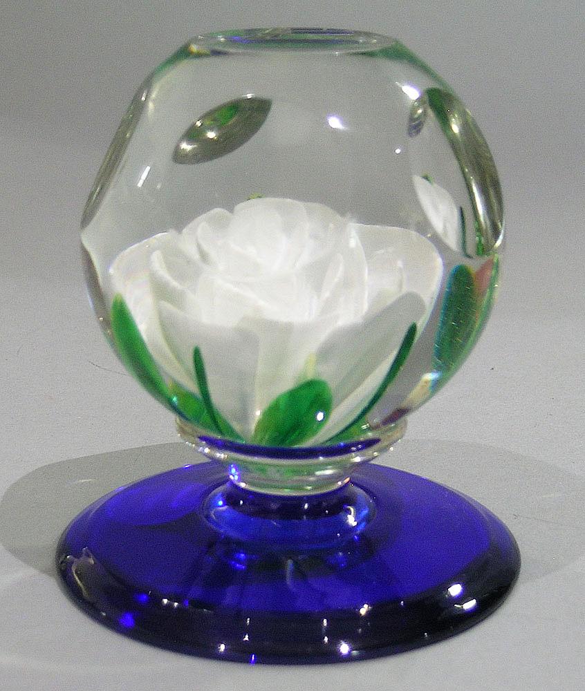 PAIRPOINT LAMPWORKFACETED PEDESTAL PAPERWEIGHT: featuring a white rose with four wide and four narrow green leaves, on a cobalt base, having paper label, 2 3/4" dia., 3 1/2" high