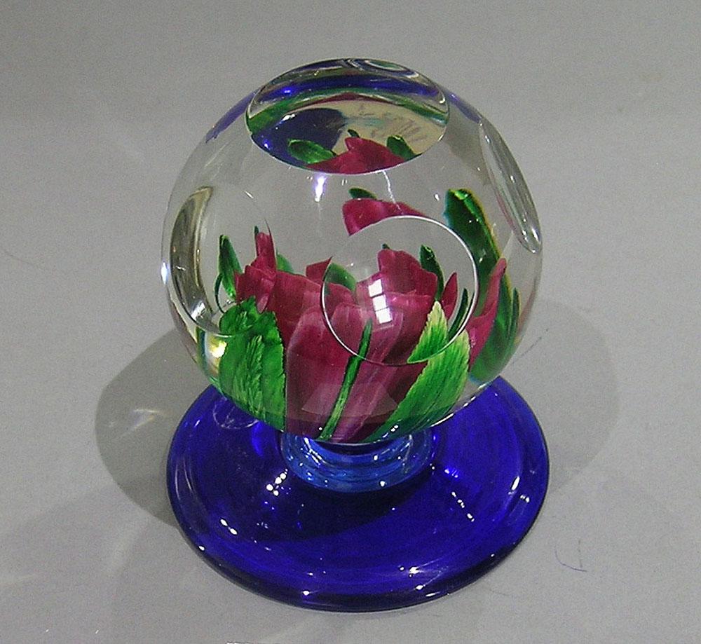 PAIRPOINT LAMPWORKFACETED PEDESTAL PAPERWEIGHT: featuring a pink rose with four wide and four narrow green leaves, on a cobalt base, signed with P in diamond mark on underside, 2 5/8" dia., 3 1/2" high