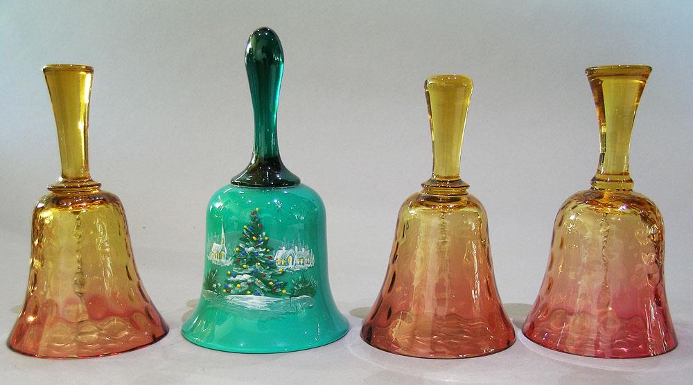 FOUR CONTEMPORARY ART GLASS BELLS: three being amberina with coin spot bells, various shaped handles, the tallest being 5 7/8" high; and one marked Pairpoint 84, green glass and having a hand painted winter village scene, 6 3/4" high