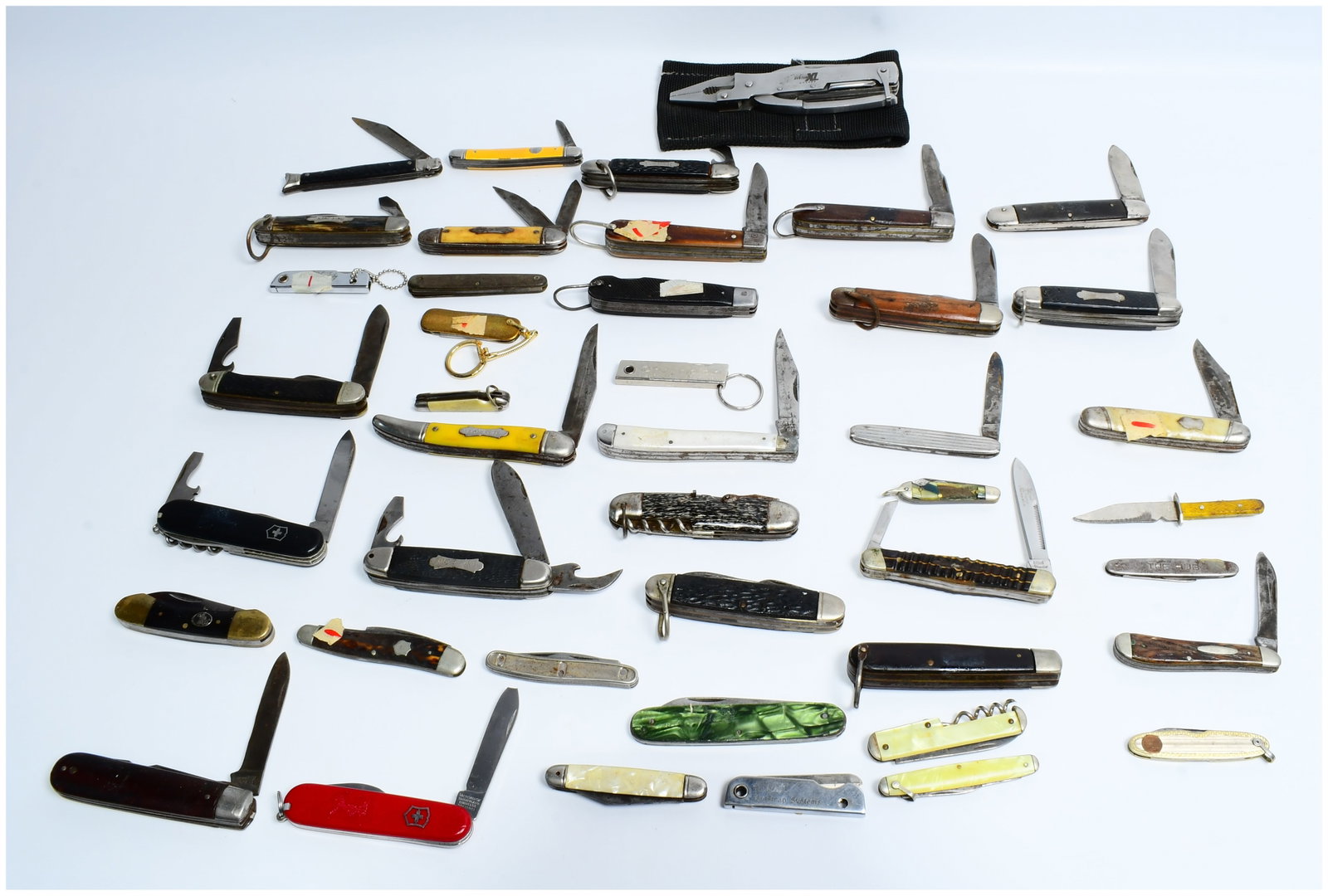 Approximately Forty Assorted Vintage and Modern Folding Pocket Knives, including Schrade, with: A collection of approximately forty assorted vintage and modern folding pocket knives, alongside one Gerber Multiplier Pro-XL multi-tool housed in a black textile pouch. The knives present a variety o
